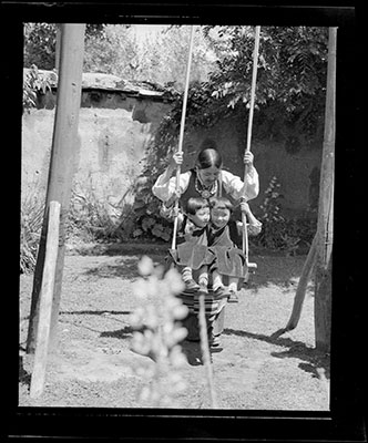Rinchen Dolma Taring pushing girls on a swing