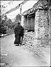Heavily clothed monk turns prayer wheel