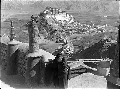 Monks blowing radung, Potala in distance