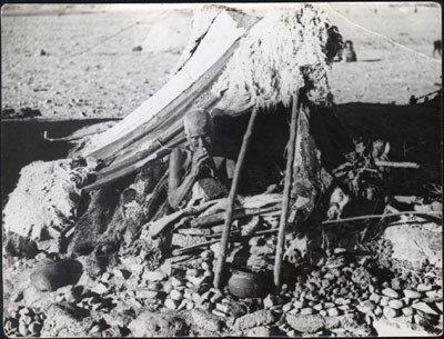 Elderly woman outside tent