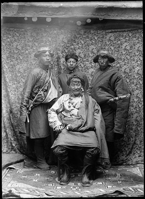 Wealthy merchant of eastern Tibet with servants. He wears a double necklace of corals and onyx. Scabbard of servant on right holds three corals, as is usual in eastern Tibet