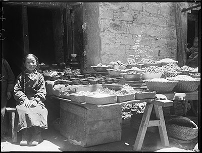 Shop in Lhasa with owner's daughter. Fruit, &c., for sale