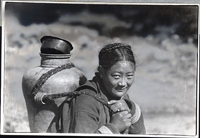 Tibetan woman carrying water jug