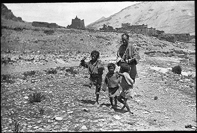 Beggar children dancing while man plays 4-stringed instrument
