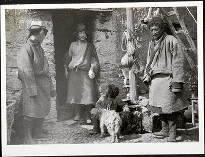 Men, a child and dogs outside a house in Ralung