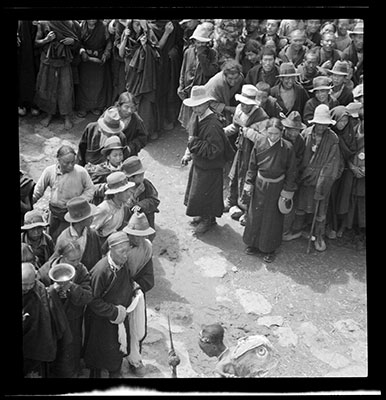 Crowd watching man carrying an Udam leather sack