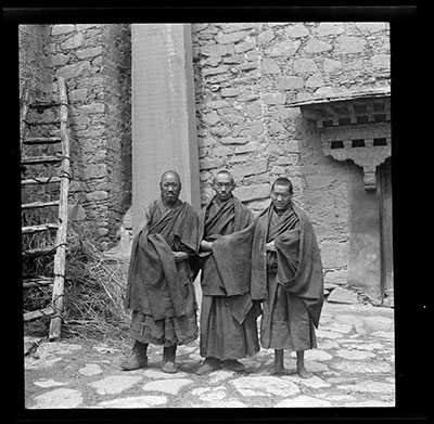 Monks in front of inscription pillar at Zhwa'i lhakhang