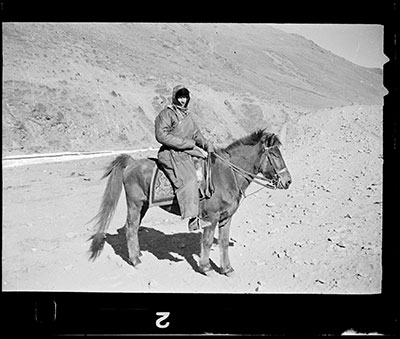 Hugh Richardson in Tibetan clothes mounted on a horse