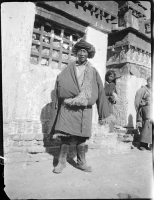 Khampa trader in front of mani wall, Gyantse
